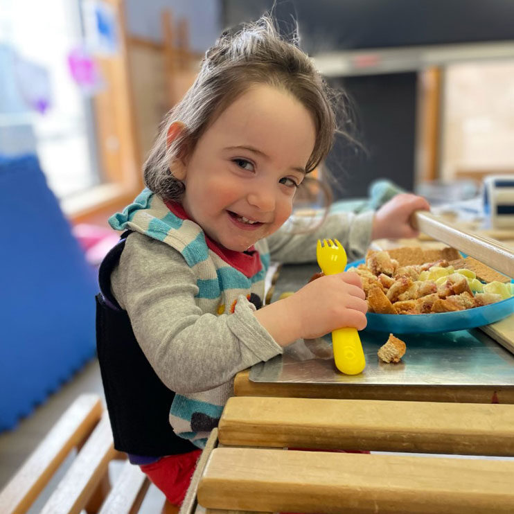 Child feeding herself during class